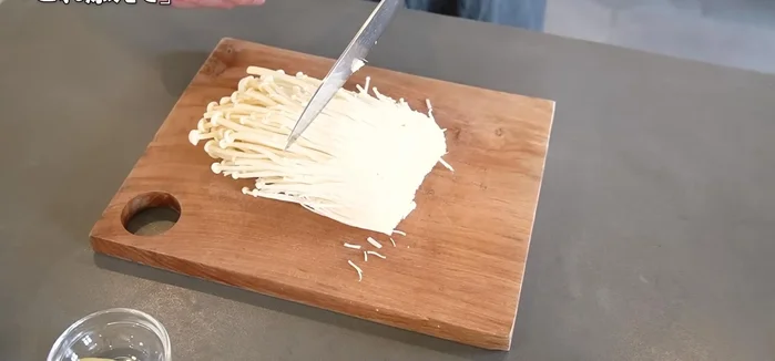 Cut off the base of the enoki mushrooms and cut them into two equal parts. Lightly loosen them.