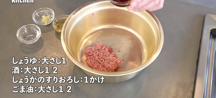 In a bowl, combine ground pork with soy sauce, sake, grated ginger, and sesame oil. Mix well.