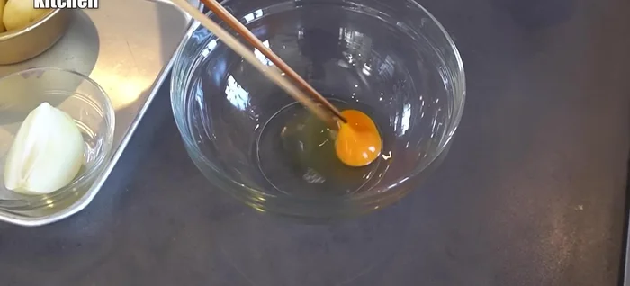 Crack eggs into a large bowl and beat lightly.