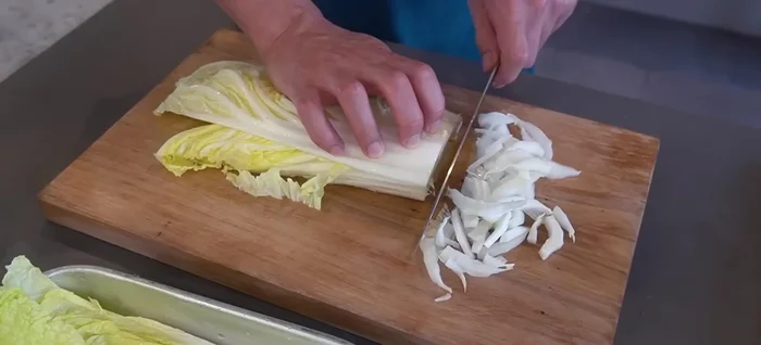 Stack the cabbage for easy cutting and slice thinly. The thinner, the better for a raw salad.