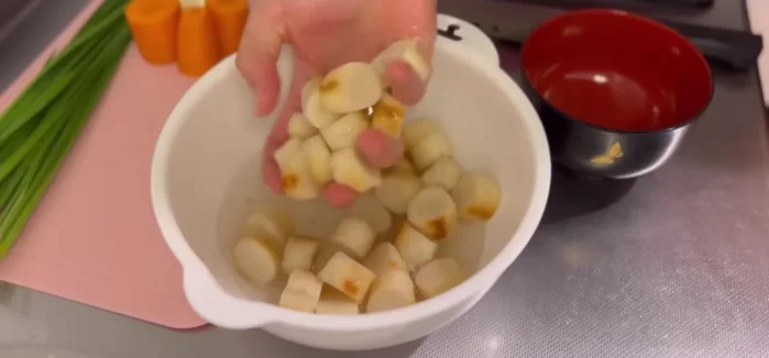 Make miso soup: Dissolve miso paste in water with enoki mushrooms and wakame seaweed.