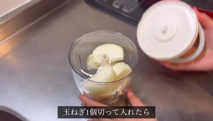Chop the onion using a chopper. (Note: The video shows using a manual chopper, but a regular chopping method can be used.)