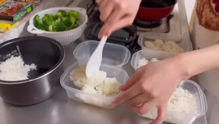 Arrange rice in Tupperware, top with oyakodon and broccoli.
