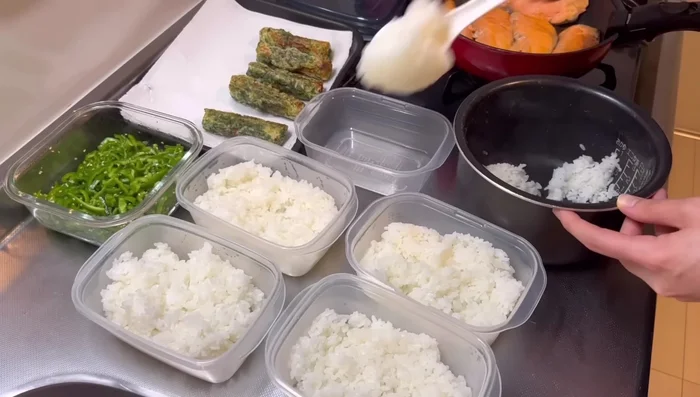 Arrange the rice in the Tupperware. Sprinkle with bonito flakes and soy sauce. Place the folded nori on top.