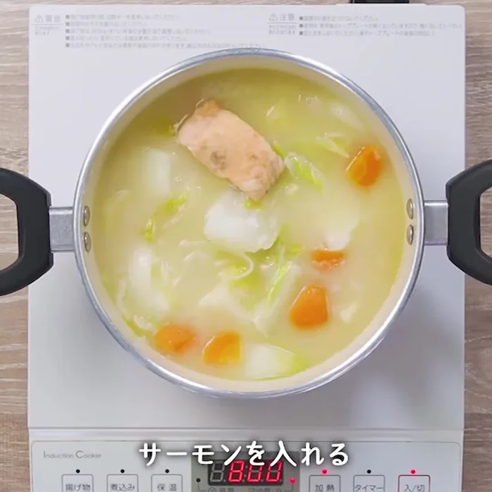 Bring the stew to a simmer, then add the Napa cabbage and salmon. Continue to simmer until the salmon is cooked through and the cabbage is tender.