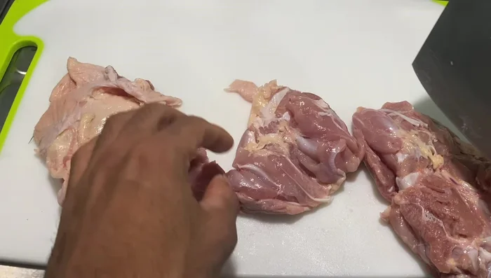 Cut the chicken thighs into pieces, leaving the skin on.