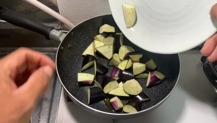 Heat sesame oil in a pan. Add green onions and stir-fry.