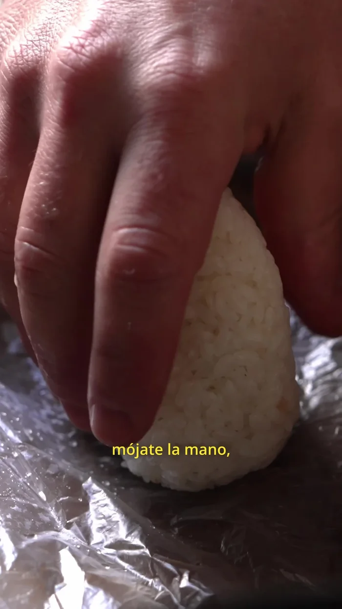 Heat a pan. Wet your hand, coat the onigiri in the egg mixture, and add a little oil to the pan. Cook the onigiri on all sides until golden brown.