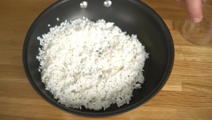 Add the drained rice to the frying pan. Add water (about the same amount as you used for soaking).