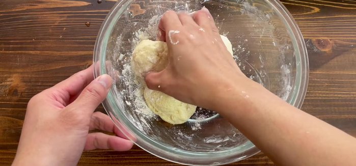 Sprinkle the dough with flour to prevent sticking. Shape it into a longer piece.