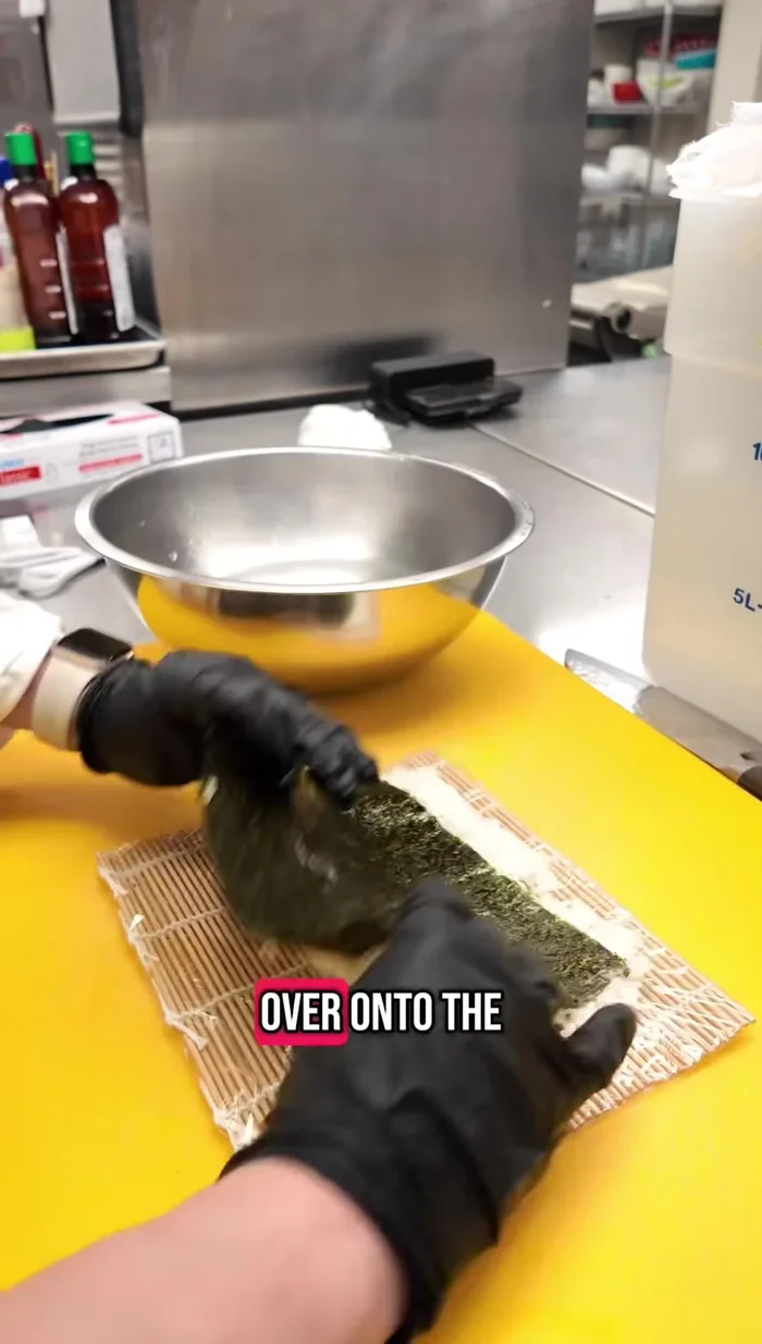 Flip the rice over onto the nori sheet, using the overhang to help.