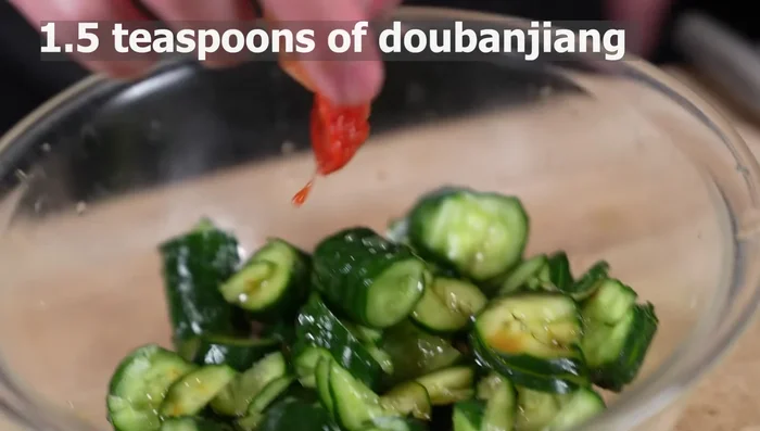 Add soy sauce, sesame oil, dubanjiang, sugar, and vinegar to cucumbers. Mix well. Refrigerate for 2-3 hours.