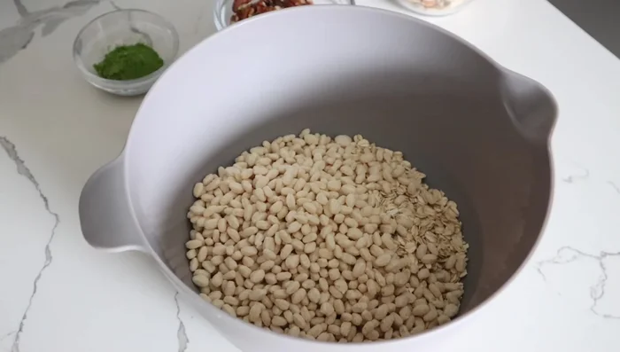 In a bowl, combine oats, rice cereal, pumpkin seeds, almonds, pecans, matcha powder, and salt.