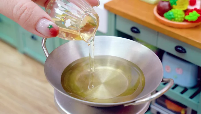 Pour the cooking oil into the pan. Put the octopus into the hot oil in the pan.