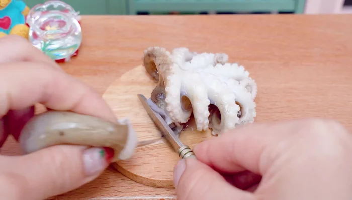 Cut the octopus in half. Cut the octopus tentacles into small pieces.