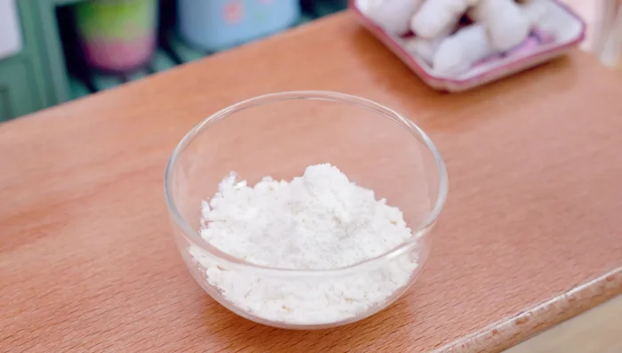 Pour the flour into the bowl. Add turmeric powder, chili powder, water. Mix well.