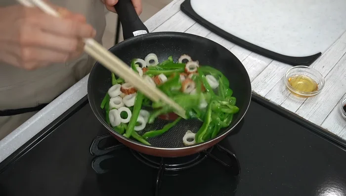 Add the chikuwa and stir-fry for about 2 minutes, until the peppers soften.