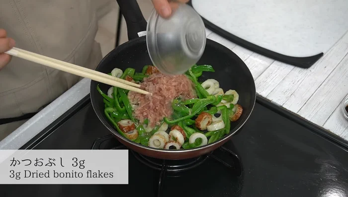 Add bonito flakes and white sesame seeds, mix.