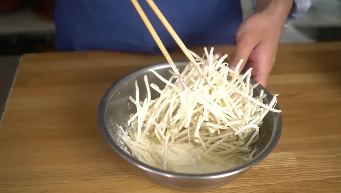 Dip the floured bean sprouts into the batter, ensuring they are fully coated.