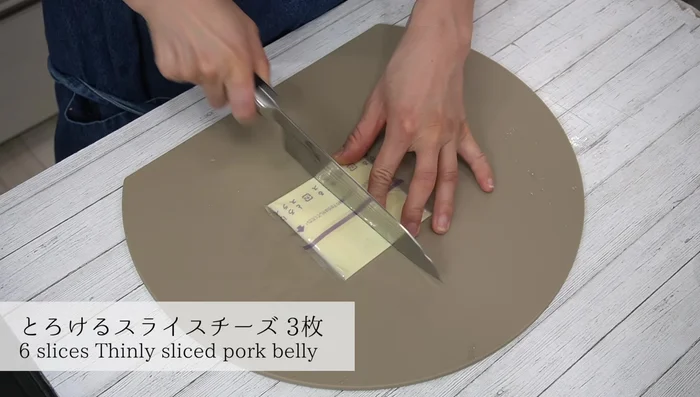 Cut the cheese slice into two equal parts. [119.36]