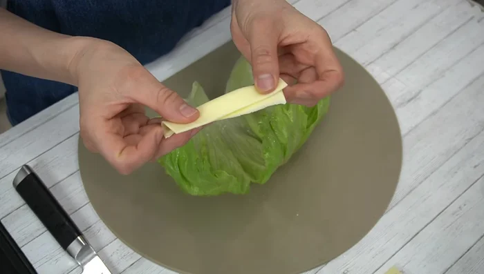 Place half a cheese slice in the middle of the lettuce. [147.56]