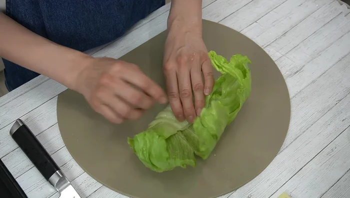 Fold the lettuce inwards and roll it up, tucking in both ends. [158.44]