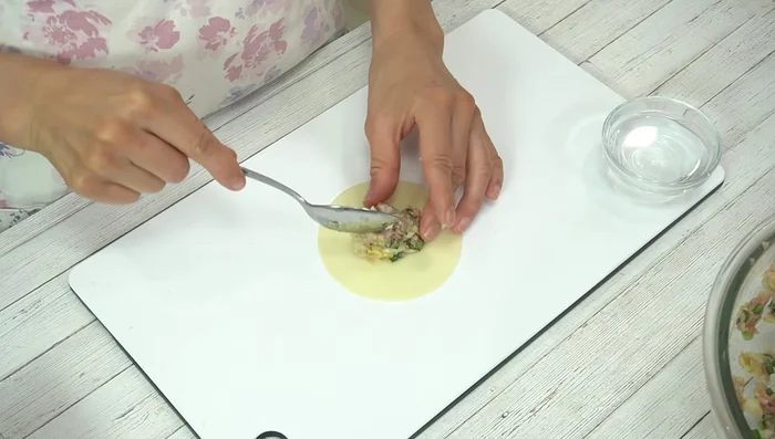 Wrap the dumplings: Place a spoonful of filling in the center of each gyoza wrapper. Wet the edges with water. Fold in half, then pinch the edges together to create a half-moon shape. Alternatively, create pleats along the edge for a more decorative dumpling.