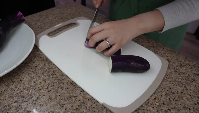 Prepare the Eggplant: Trim eggplant ends. Slice into rounds or half-moons. Soak in water to remove bitterness. Chop green onions for garnish.