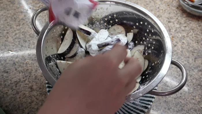Cook the Eggplant: Drain eggplant, coat with potato starch. Heat oil in a pan. Add eggplant and air fry until tender and golden. Pour in sauce, coat evenly. Transfer to a serving dish and sprinkle with green onions.