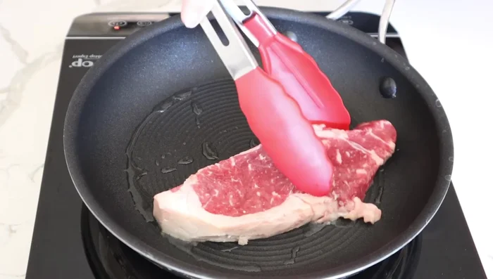 Heat a frying pan over medium-high heat with oil. Cook the steak for 2-3 minutes per side until browned, then cook to desired doneness.