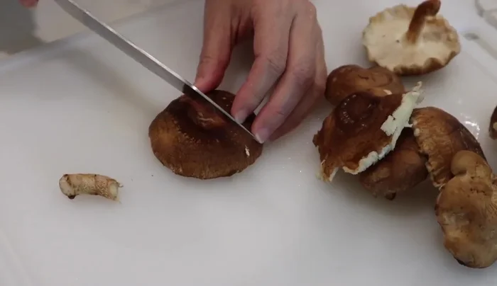 Remove stems from shiitake mushrooms and make decorative star cuts on top.