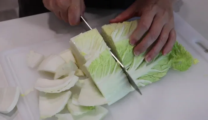 Cut napa cabbage into 2-inch wide pieces. Cut onion in half, then slice into half-inch thick rounds.