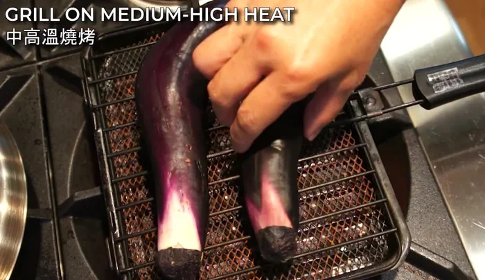 Place the eggplants on a grilling rack and grill on medium-high heat until the skin is burned and wrinkled (about 15 minutes total, 5 minutes per side). Rotate the eggplants for even grilling.