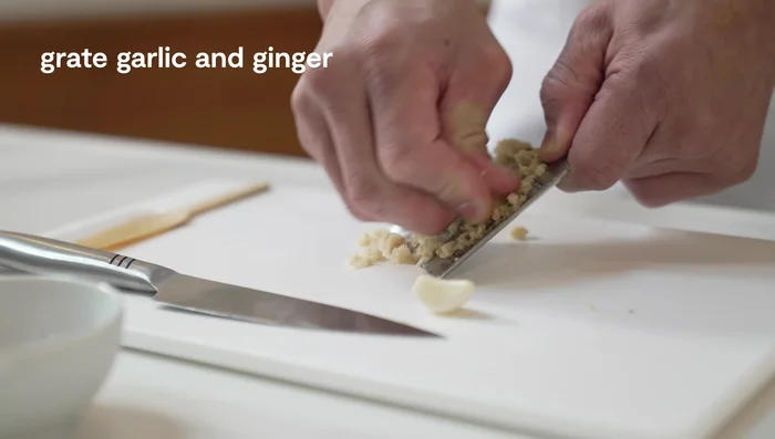 Grate 1 inch of peeled ginger and 1 clove of garlic.