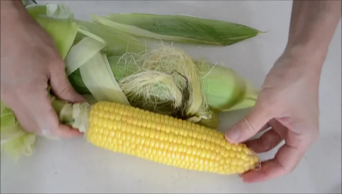 Place the corn in a frying pan and sprinkle with two tablespoons of something (unclear from transcript). [38.16]