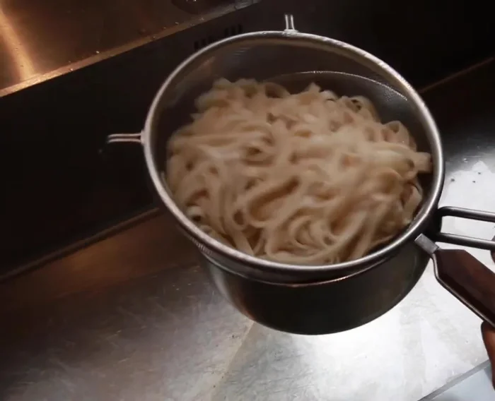 Drain the cooked udon noodles. Add 2 tbsp of Clear Spring Barley Miso paste to the vegetable mixture and stir until dissolved.