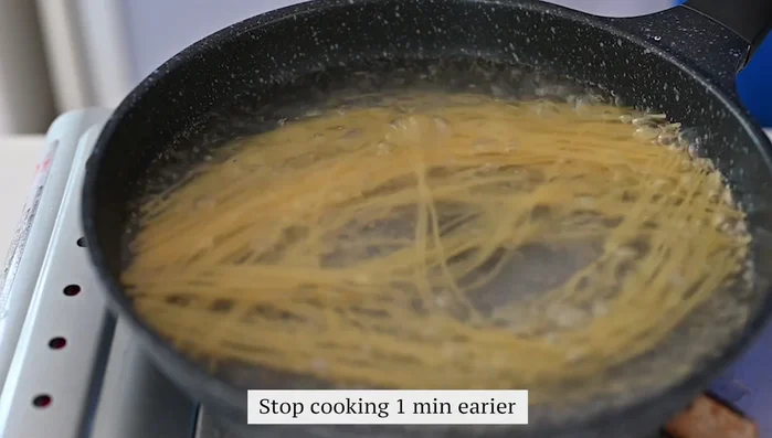 Cook spaghetti until one minute before it's fully cooked.