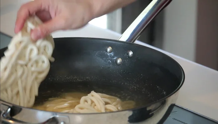 Add the frozen udon noodles to the broth and cook until heated through. (216.4)