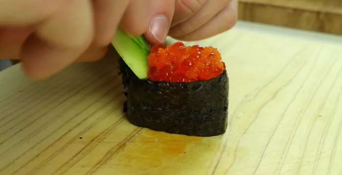 Place the cucumber slices on one side of the maki roll.