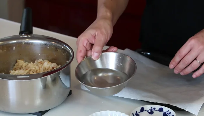 Prepare an oven sheet lined with parchment paper. Wet your hands and sprinkle salt on your palms. Shape the rice mixture into triangles or balls, using a small bowl as a guide for even size.