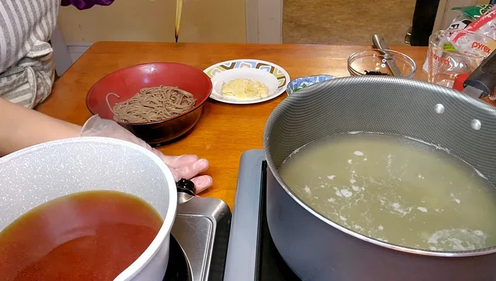 Add the cooked soba, wakame, and aburaage to the soup. (305.44, 319.28, 327.919)