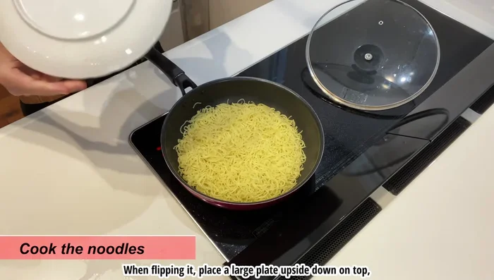 Flip the noodles using a large plate to help, and fry the other side for about 3 minutes.