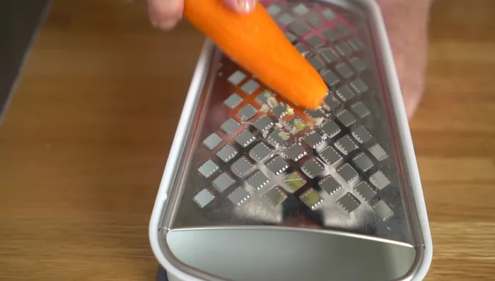 In a bowl, combine the grated garlic and carrot.