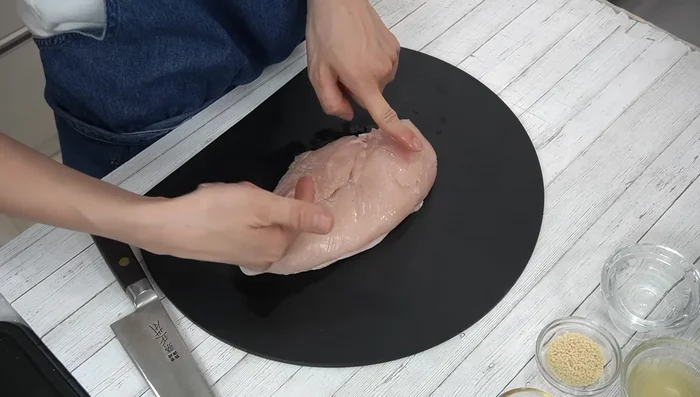 Cut the chicken breast into bite-sized pieces, cutting across the fibers. It's easier if you separate the fibers first.