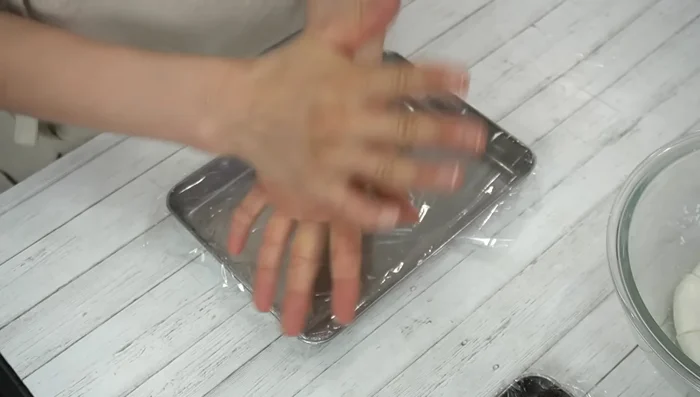 Roll each portion into a ball, flatten slightly, and place a portion of anko in the center.