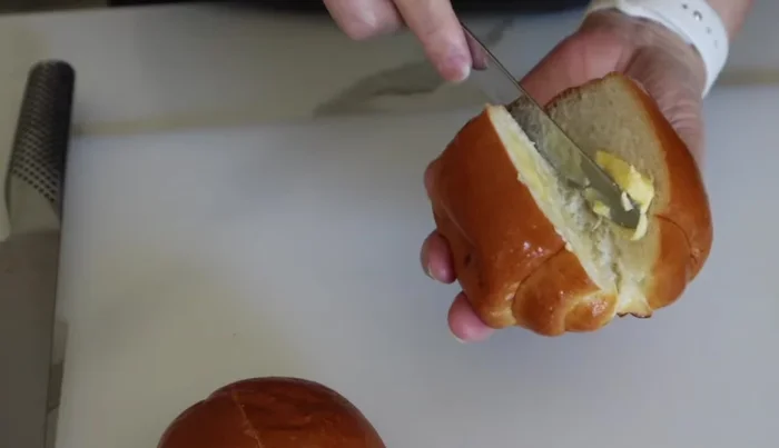 Butter the inside of the rolls. Wrap each roll in aluminum foil and put them in a toaster oven to keep warm.