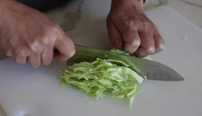 Cut cabbage thinly and make diagonal cuts on the surface of the sausages.