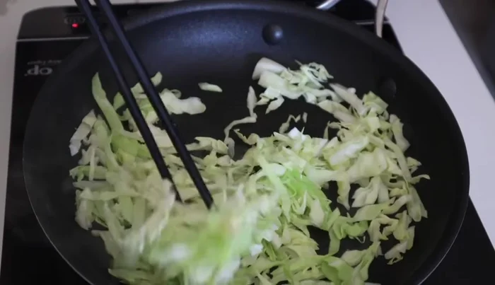 In a clean pan, heat oil over medium heat and cook the shredded cabbage until softened. Season with salt, curry powder, and rice vinegar.