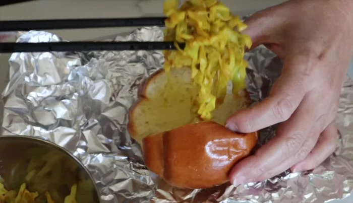 Fill the roll with the cabbage mixture and top with the sausage.