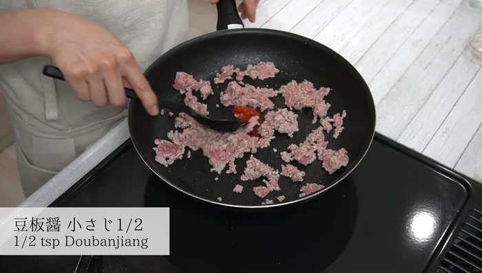 Add the chili pepper (if using) and stir-fry until fragrant. Then add green onions and stir-fry until cooked.